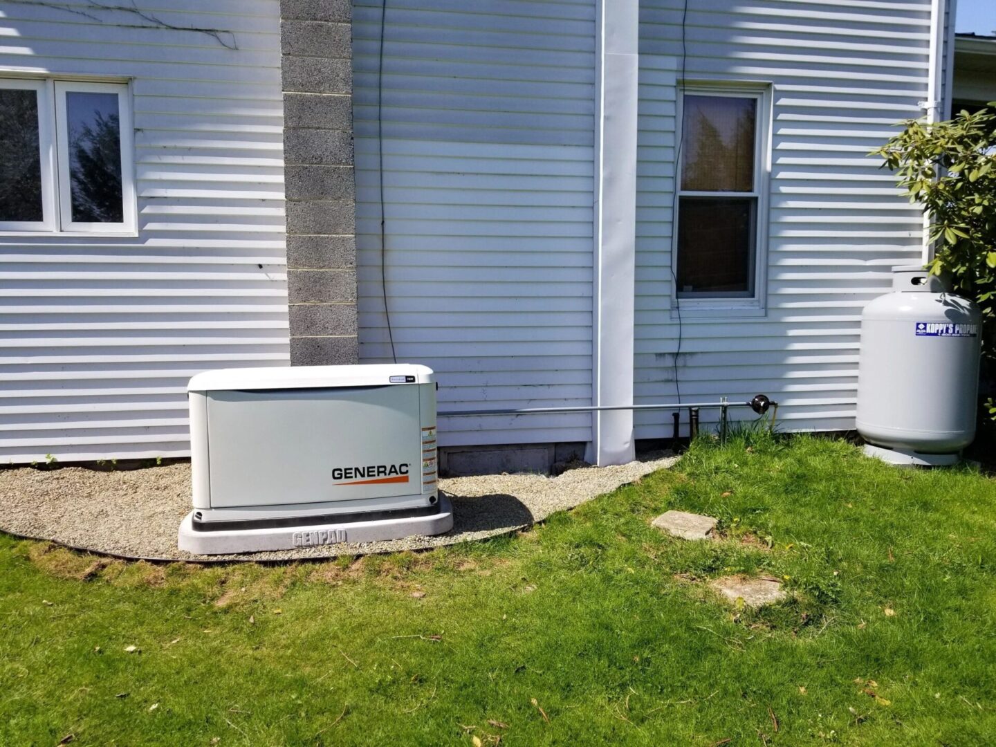 A home with an outdoor generator outside of it.