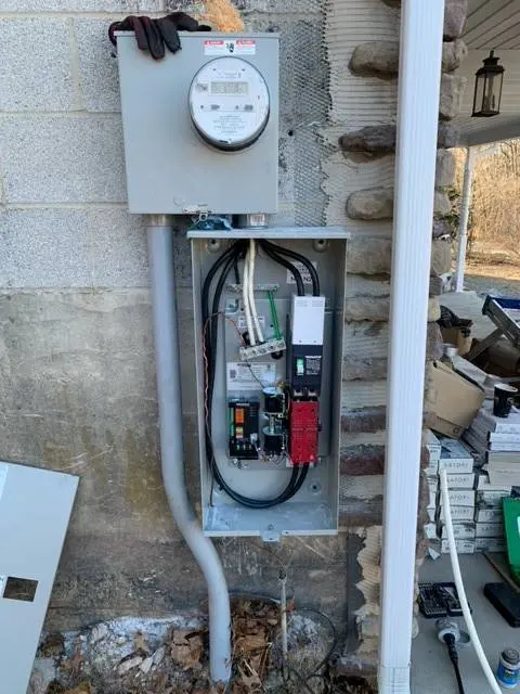 A fuse box with wires and an electrical meter.