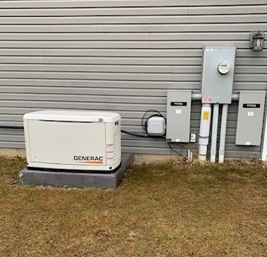 A generator is connected to the wall of an electrical panel.